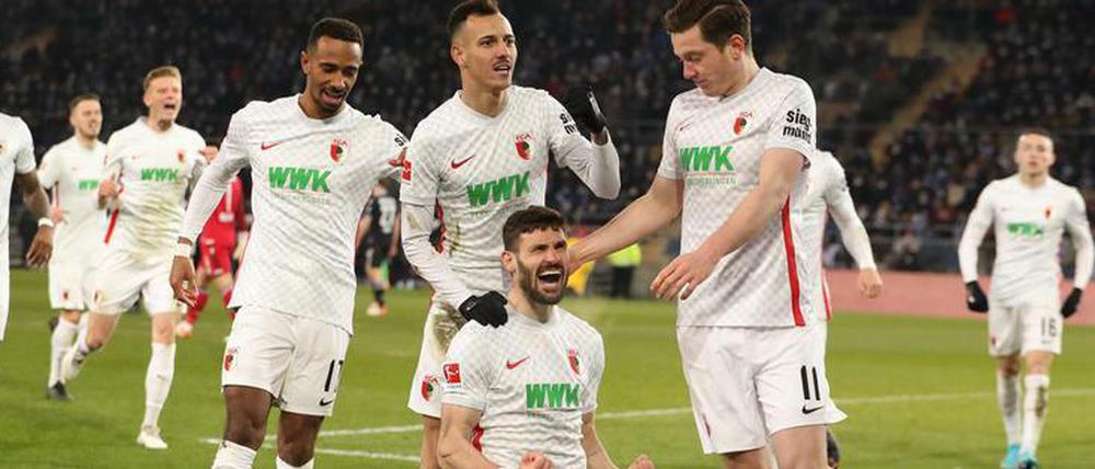 Die Augsburger feiern ihren Siegtorschützin Daniel Caligiuri.