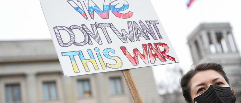 Eine Frau hält vor der russischen Botschaft in Berlin ein Plakat gegen den Krieg in der Ukraine.