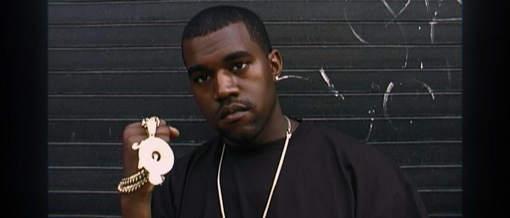 Ein junger Kanye West zeigt seinen Schmuck.