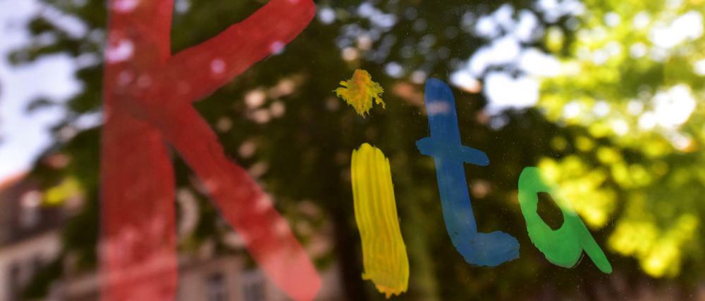 Der bunte Schriftzug «Kita» ist in München mit Fingerfarbe auf die Fensterscheibe einer Kindertagesstätte gemalt (Symbolbild).