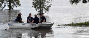 Bewohner fahren mit einem Boot durch überflutete Teile der australischen Stadt Lawrence.