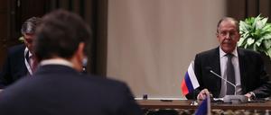 Russlands Außenminister Sergej Lawrow sitzt vor seinem ukrainischen Amtskollegen Dmytro Kuleba.