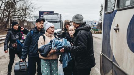 Menschen mit Kindern warten darauf, den Fluss Irpin zu überqueren.