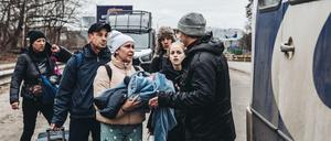 Menschen mit Kindern warten darauf, den Fluss Irpin zu überqueren.