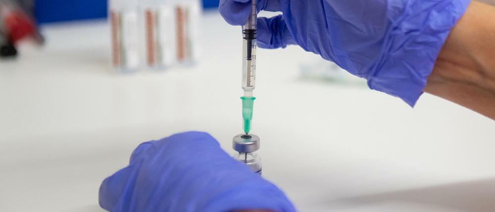 Eine Arzthelferin zieht in eine Spritze eine Kochsalz-Lösung zur Verdünnung von Corona-Impfstoff von Biontech auf.