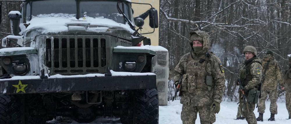 Ukrainische Soldaten stehen am Stadtrand von Charkiw.