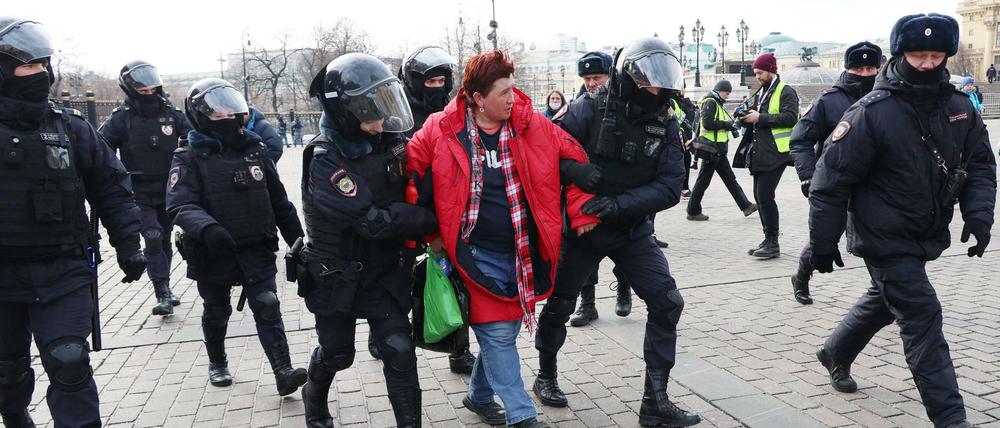 Polizisten nehmen eine Demonstrantin in Moskau fest.