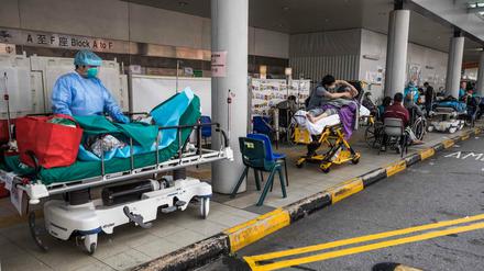 Patienten warten außerhalb eines Krankenhauses in Hongkong auf ihre Behandlung.