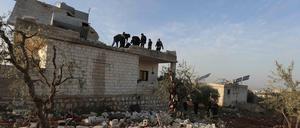 Menschen versammeln sich auf dem zerstörten Haus, in dem der ehemalige IS-Anführer Abu Ibrahim al-Hashimi al-Qurashi starb.