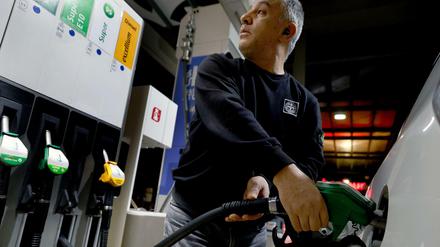 Ein Taxifahrer tankt an einer Tankstelle sein Fahrzeug mit Benzin.