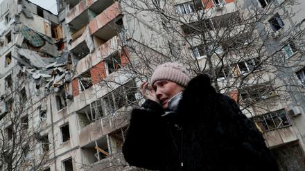 Eine Frau vor einem zerstörten Haus in Mariupol