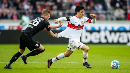 Augsburgs Frederik Winther (li.) zerrt am Trikot von Stuttgarts Wataru Endo (re.). Den Heimsieg von Stuttgart kann er dann aber auch nicht verhindern.