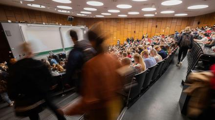Studierende sitzen in einem Hörsaal, andere suchen noch einen Platz.