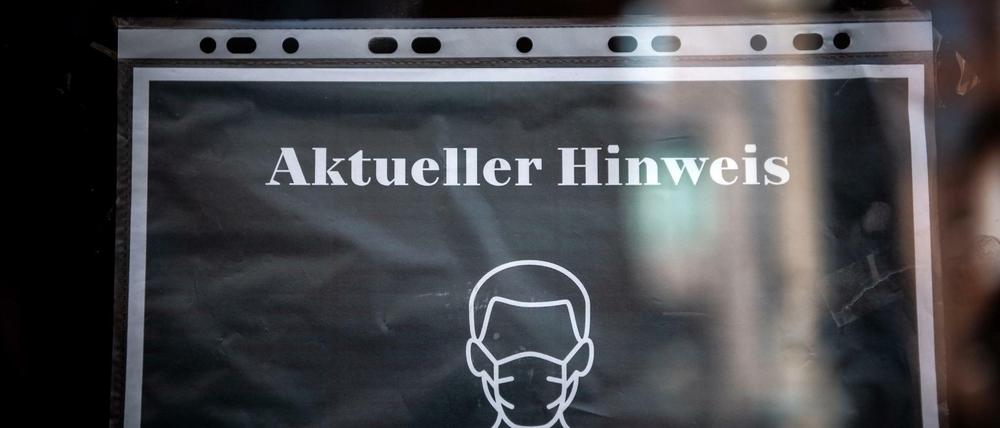 Ein Schild an einem Restaurant informiert über die FFP-2 Maskenpflicht.