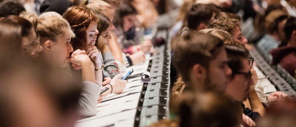 Studierende sitzen dichtgedrängt in einem Hörsaal.