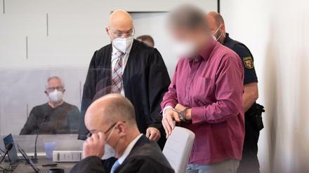 Der Angeklagte im Prozess um den Tankstellen-Mord wird in Handschellen in den Gerichtssaal gebracht.