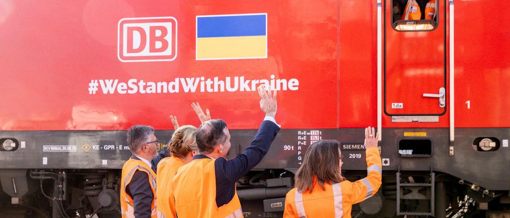 Andrij Melnyk (links im Bild), Botschafter der Ukraine in Deutschland, Franziska Giffey (SPD), Regierende Bürgermeisterin von Berlin, Volker Wissing (FDP), Bundesminister für Verkehr und Digitales, und Sigrid Nikutta, Vorstand Güterverkehr Deutsche Bahn, winken dem Lokführer eines Zuges mit Hilfsgütern für die Ukraine. Der Zug ist Teil der DB-Schienenbrücke mit Hilfsgütern und fuhr im Westhafen los.