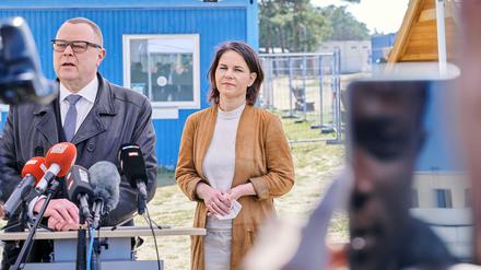 Brandenburgs Innenminister Michael Stübgen (CDU) spricht neben Bundesaußenministerin Annalena Baerbock (Bündnis 90/ Die Grünen) bei einem gemeinsamen Besuch in der Zentrale Erstaufnahmeeinrichtung für Asylbewerber in Eisenhüttenstadt. 