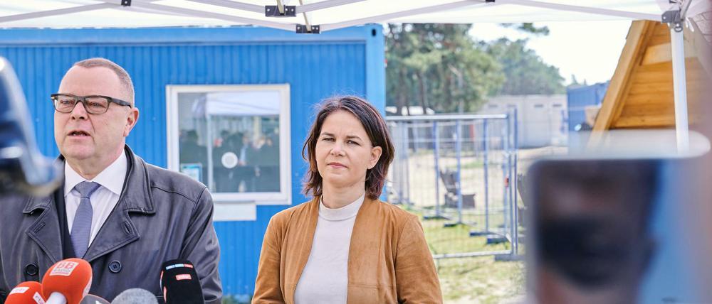 Brandenburgs Innenminister Michael Stübgen (CDU) spricht neben Bundesaußenministerin Annalena Baerbock (Bündnis 90/ Die Grünen) bei einem gemeinsamen Besuch in der Zentrale Erstaufnahmeeinrichtung für Asylbewerber in Eisenhüttenstadt. 