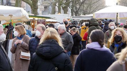 Auf einem Marktplatz in Deutschland tragen manche Besucher eine Mund-Nasenschutz-Maske