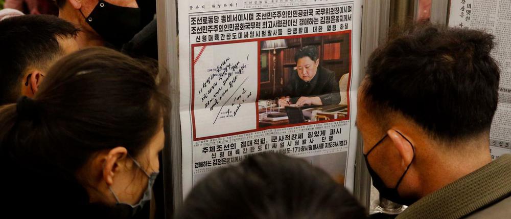 Nordkoreaner lesen in Pjöngjang Berichte über einen Raketentest ihres Landes (Aufnahme vom 25. März 2022).