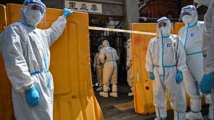Mit einer Plastikmauer riegeln Mitarbeiter der Gesundheitsbehörden einen Wohnkomplex in Shanghai ab.