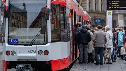 Fahrgäste steigen in Halle/Saale an einer Straßenbahnhaltestelle in die Bahn. 