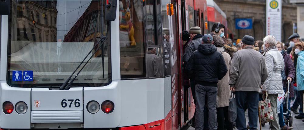 Fahrgäste steigen in Halle/Saale an einer Straßenbahnhaltestelle in die Bahn.
