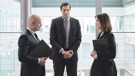 Ménage à trois.  Magnus Mittendorf (Christian Berkel, links) lernt seine neue Pressesprecherin Katharina Borba (Friederike Becht) kennen – von ihrer Beziehung zu seinem Personenschützer Jonas Neimann (Max Simonischek) weiß er nichts. Foto: Schroeder/ZDF