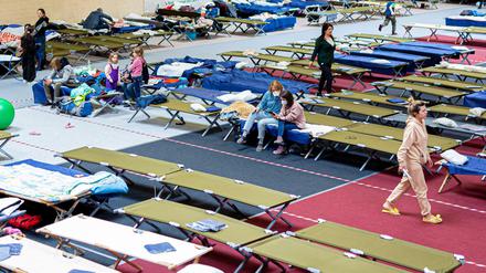 Geflüchtete aus der Ukraine sitzen in einer Flüchtlingsunterkunft. Der Bund will sich um eine gerechte Verteilung kümmern.
