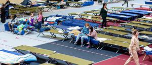 Geflüchtete aus der Ukraine sitzen in einer Flüchtlingsunterkunft. Der Bund will sich um eine gerechte Verteilung kümmern.