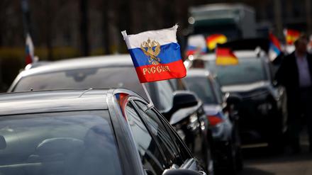 Flaggen mit den russischen Nationalfarben wehen an einem Auto auf dem Olympiaplatz in Berlin.