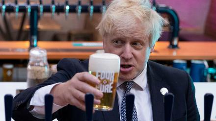 Boris Johnson, Premierminister von Großbritannien, hält bei einem Besuch in der Fourpure-Brauerei ein Bier in der Hand.