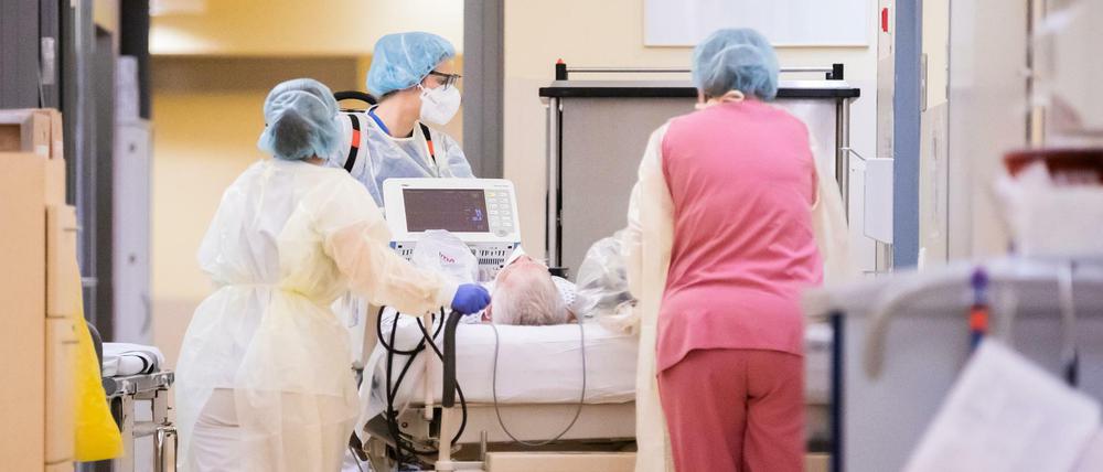 Intensivfachpflegerinnen betreuen einen Patienten.