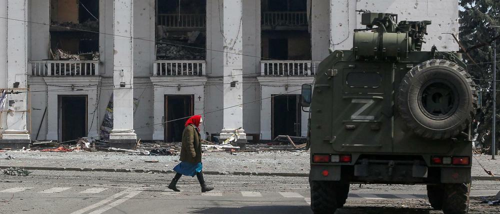 Eine Frau passiert im ostukrainischen Mariupol einen Panzerwagen pro-russischer Truppen. 