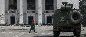 Eine Frau passiert im ostukrainischen Mariupol einen Panzerwagen pro-russischer Truppen. 