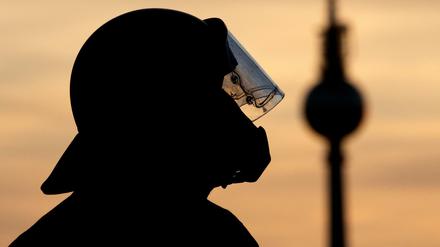 Die Silhouette eines Polizisten vor dem Fernsehturm. Symbolbild.