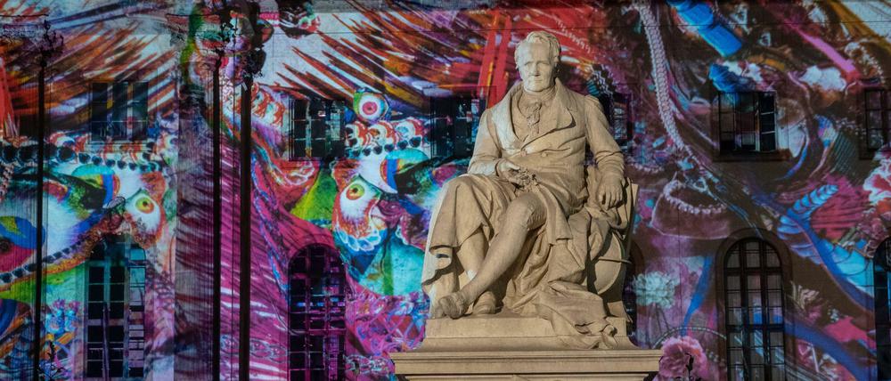 Eine Statue Alexander von Humboldts vor dem Hauptgebäude der Humboldt-Uni - mit farbiger Projektion beim Festival of Lights.