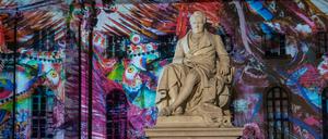 Eine Statue Alexander von Humboldts vor dem Hauptgebäude der Humboldt-Uni - mit farbiger Projektion beim Festival of Lights.