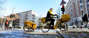 Ein Briefzusteller der Deutschen Post unterwegs auf dem Rad in der Reichenberger Straße in Kreuzberg. 