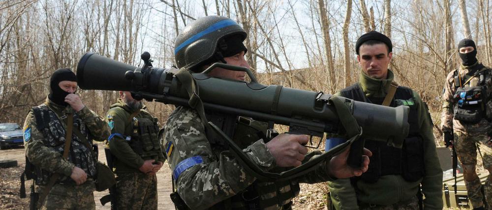 Ukrainische Soldaten nahe Charkiw studieren ein schwedisches schultergestütztes Waffensystem während einer Übung.
