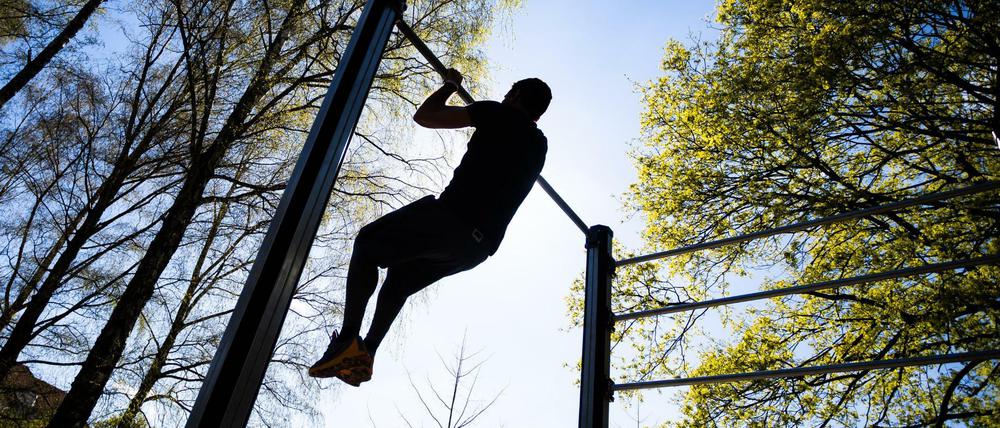 Bloß nach draußen bei dem Wetter: Ein Mann macht Klimmzüge im Volkspark Wilmersdorf.