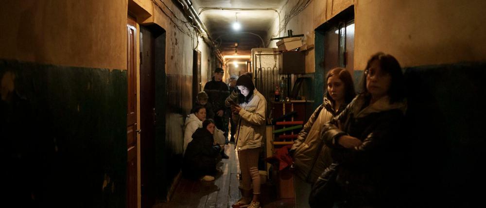 Menschen stehen im Flur ihres Wohnhauses während die russischen Angriffe in Charkiw weitergehen.