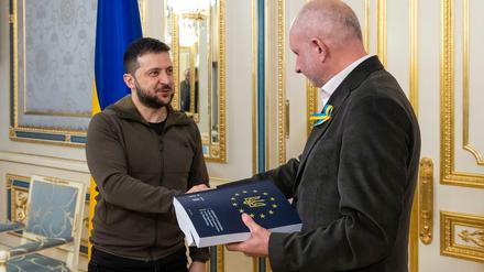 Wolodymyr Selenskyj (l) überreicht Matti Maasikas, Leiter der Delegation der EU in der Ukraine, den beantworteten Fragebogen für einen EU-Beitritt.