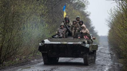 Ukrainische Soldaten fahren auf einem gepanzerten Kampffahrzeug an einem unbekannten Ort in der Ostukraine.