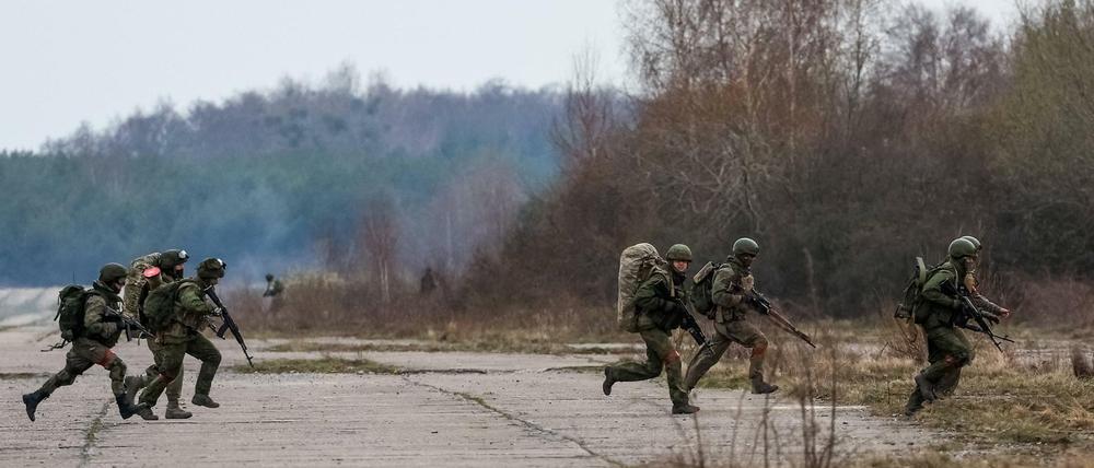 Bei einer Militärübung läuft eine Gruppe Soldaten über ein freies Feld. 
