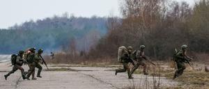 Bei einer Militärübung läuft eine Gruppe Soldaten über ein freies Feld. 