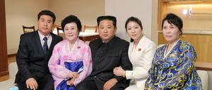 Händchen halten mit oberstem Führer. Kim Jong-un (Mitte) posiert mit Chefsprecherin Ri Chun-hee (zweite von links) and ihrer Familie in der Wohnung, die der Diktator Ri geschenkt hat. 