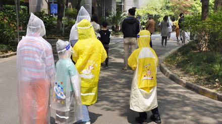 Bewohner einer Wohnanlage warten auf die Durchführung von PCR-Tests. In Shanghai läuft seit Ende März 2022 ein weitgehender Lockdown. 