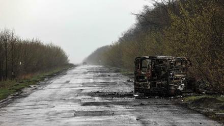 Ein ausgebrannter Van liegt auf einer Straße in der Donbass-Region.